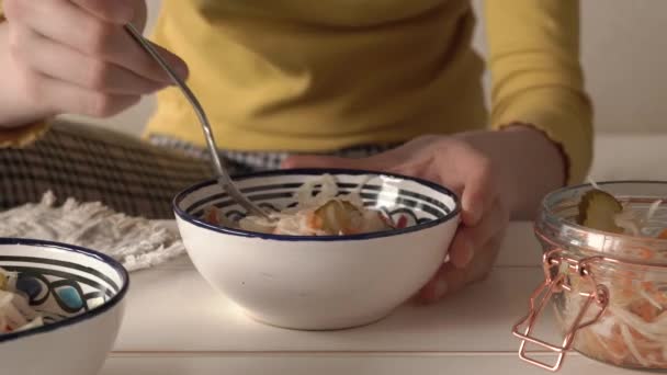 女孩的手从一个有叉子的碗里取出发酵的卷心菜 — 图库视频影像