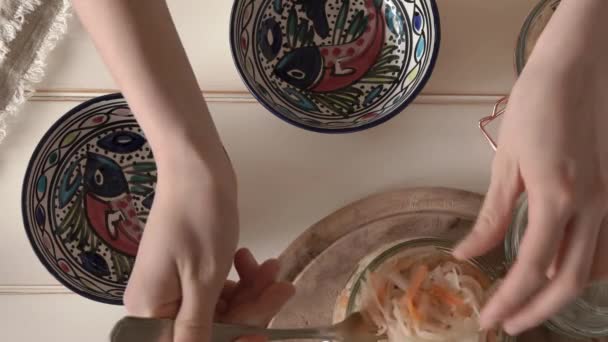 女孩的手把发酵的卷心菜从罐子放进碗里 — 图库视频影像