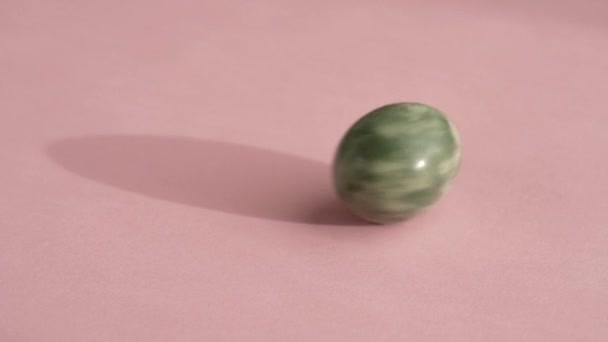 Huevo Jade Verde Girando Sobre Fondo Rosa Cámara Lenta — Vídeo de stock