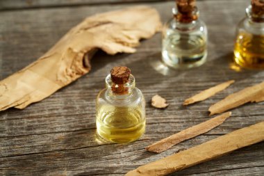 Aromaterapi şişeleri beyaz sandal ağacı parçalarıyla gerekli yağ