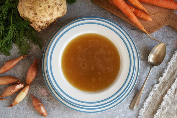 Caldo Osso Uma Placa Branca Azul Com Cenouras Cebolas Raiz — Fotografia de Stock