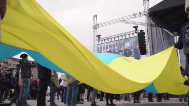 PRAG, CZECH REPUBLIC - 3 Nisan 2022: Rus saldırısına karşı destek olmak amacıyla Letna yardım konserinde büyük bir Ukrayna bayrağı tutan insanlar