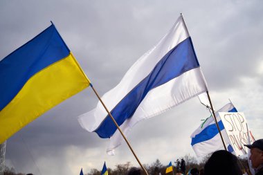 PRAG, CZECH REPUBLIC - 3 Nisan 2022: Ukrayna ve beyaz-mavi-beyaz bayraklar, Rusya 'nın Ukrayna' ya faydalı bir konserde saldırmasını sembolize ediyor