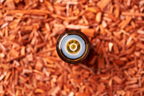 Koyu bir şişe aromaterapi kırmızı sandal ağacı parçacıkları ile gerekli yağ, üst görünüm