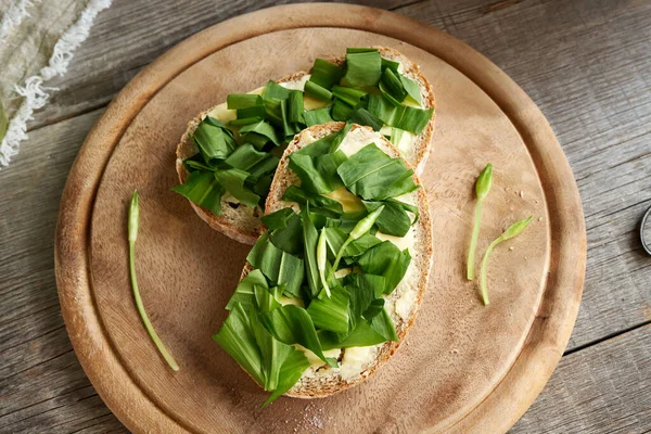 Baharda ekşi ekmek dilimlerinde yabani sarımsak yaprakları ve tomurcuklar.