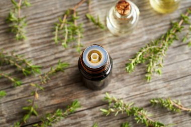Koyu bir şişe aromaterapi. Taze kekik dallarıyla gerekli yağ.
