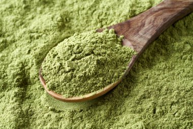 Tahta kaşıkta yeşil arpa tozu. Besin takviyesi, yakın plan.