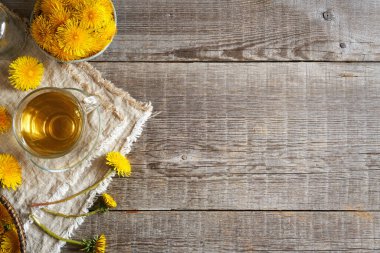 Taze karahindiba çiçekleri ve ahşap zemin üzerinde çay fotokopi alanı ile bitkisel ya da alternatif tıp.