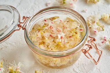 Bitkisel tentürü hazırlamak için at kestanesi çiçeği ve alkol dolu cam bir kavanoz.