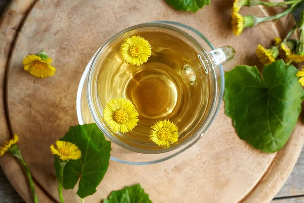 Taze yaka çiçekli ve yapraklı bir fincan bitki çayı.