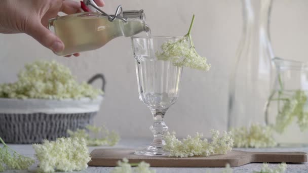 瓶から古い花シロップを新鮮な花で飾られたガラスに入れます — ストック動画