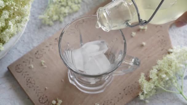 自家製の古い花シロップを氷の入ったガラスに入れる — ストック動画
