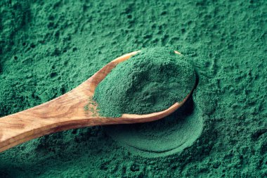 Ahşap bir kaşıkta yeşil arka planda
