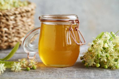 Baharda taze ıhlamur çiçekleriyle dolu cam bir kavanoz bal.