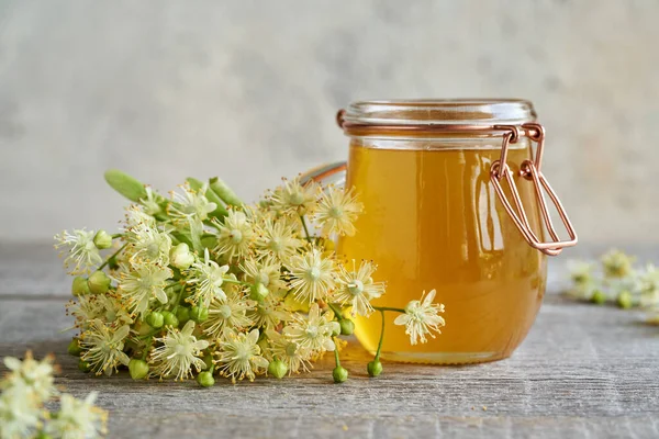 Masadaki bal kavanozuyla taze ıhlamur çiçekleri.