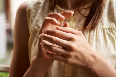 Hands of a girl practicing EFT or emotional freedom technique - tapping on the karate chop point
