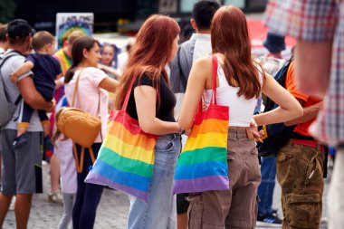 PRAGUE, CZECH REPUBLIC - AUGUST 13, 2022: LGBT women with colorful rainbow bags at the Wenceslas square during gay pride