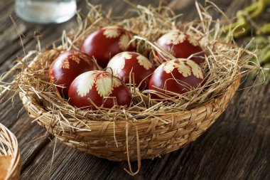 Easter eggs colored with onion peels in a wicker basket on a rustic table