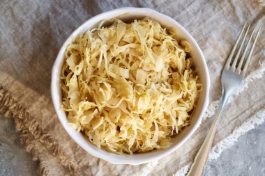 Homemade fermented cabbage or sauerkraut in a bowl on a table, top view