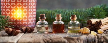 Panoramic Christmas banner with bottles of essential oil with frankincense, cinnamon, fir and star anise