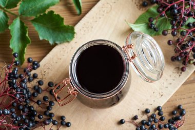 Arka planda taze böğürtlenli ev yapımı siyah yaşlı şurubu.