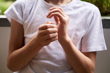 Hands of a little boy practicing EFT or emotional freedom technique - tapping on the side of the hand point