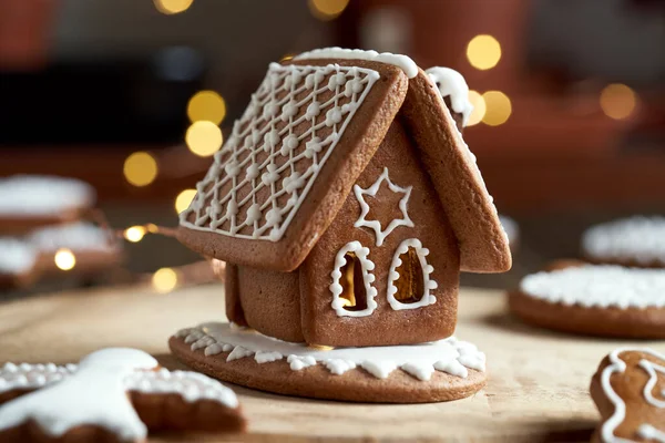 Christmas gingerbread house with white icing, with bokeh in the background