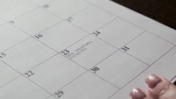 手はカレンダーの日付をマーカーで囲みます 2月23日 祖国の日の防衛者 — ストック動画