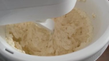 Gezegen karıştırıcısı kaymak hamurunu yoğuruyor. Ev yapımı süzme peynirli hamur işleri. Süzme peynirli kekler. Tüm aile için protein kahvaltısı..