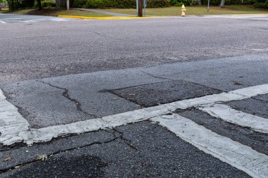 Yaya geçidi boyalı, çatlak ve yıpranmış yol yüzeyi, yaratıcı kopya alanı, yatay görünümü olan iki caddenin kesiştiği geniş bir görüş alanı.