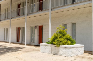 Genel apartman binası, kırmızı kapılı beyaz tuğla, büyük tuğla ekicisi, yatay görünüm.