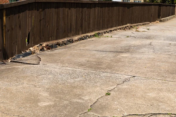 Cracked Driveway Crumbling Curb Dark Wood Fence Running Alongside Creative — Stock Photo, Image