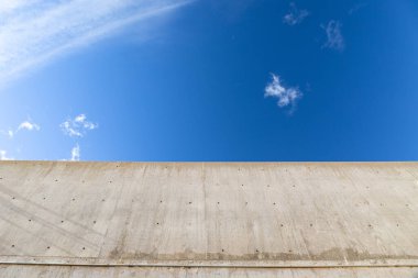 Aşağıdan görünen gri dökme beton köprü yapısı, bulutlu mavi gökyüzü, yaratıcı kopya alanı, yatay görünüm