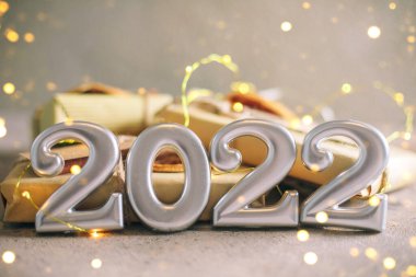 Noel tebrik kartı. 2022 numara ve tatil arkaplanındaki hediye yığını. Noel ışıkları arka planda. Mutlu yıllar 2022, noeller, bayram kutlamaları. Boşluğu kopyala