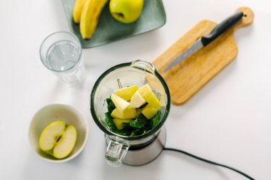 Blender ile yeşil detoks smoothie hazırlama işlemi. Vejetaryen bahar içkileri. Dikkatli yemek yeme, diyet yapma kavramı. Üst görünüm