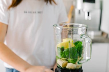 Blender ile yeşil detoks smoothie hazırlama işlemi. Vejetaryen bahar içkileri. Dikkatli yeme, diyet yapma kavramı