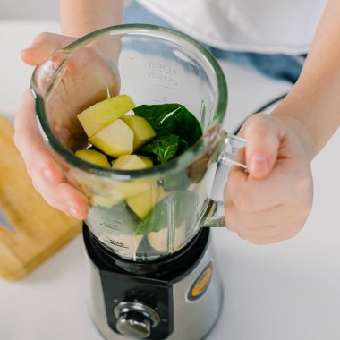 Blender ile yeşil detoks smoothie hazırlama işlemi. Vejetaryen içkileri. Özenli yemek kavramı. Üst görünüm