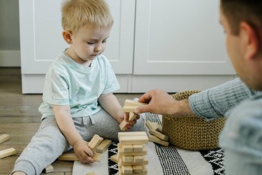 Mutlu baba ve küçük çocuk evdeki çocuk odasında tahta bloklarla oynayan küçük oğul. Aile hayatı, erken çocuk gelişimi, çocuk oyuncağı konsepti..
