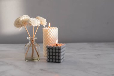 Ev aroması yayıcı ve mermer arka planda yanan mumlar. İç unsurlar. Ev aroması. Zindelik