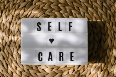 Lightbox with text Self care. Flat lay. Concept of mental health, mindfulness lifestyle. Top view