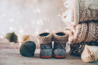 Kış örgü süveterler, şirin botlar ve Bokeh ile bulanık bir arkaplanda Noel süsleri. Sıcak ve samimi bir kavram. Boşluğu kopyala