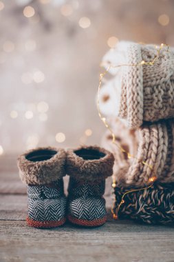 Kış örgü süveterler, şirin botlar ve Bokeh ile bulanık bir arkaplanda Noel süsleri. Sıcak ve samimi bir kavram. Boşluğu kopyala.