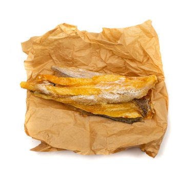 Buruşmuş kağıt üzerinde kurutulmuş balık çubukları. Kuru tuzlu deniz ürünleri, hake stok balığı, küçük susuz pollock parçaları, bira aperatifleri, beyaz arka planda kurutulmuş balık filetosu.