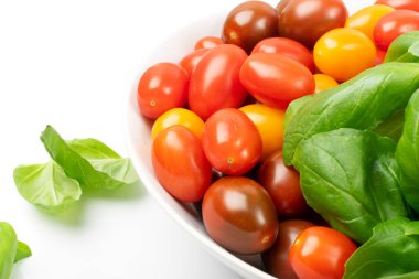 Uzun erik domates grubu izole edildi. Taze kırmızı, kahverengi ve sarı kiraz domatesleri, beyaz arka planda küçük organik domates karışımı.