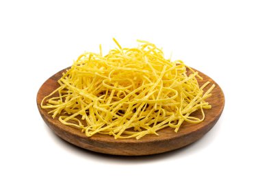 Çiğ sarı İtalyan tagliatelle makarnası. Ev yapımı kuru erişte, ince makarna kurdeleleri, izole edilmiş kısa pişmemiş spagetti yığını.