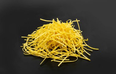 Çiğ sarı İtalyan tagliatelle makarnası. Ev yapımı kuru erişte, ince makarna kurdeleleri, pişirilmemiş kısa spagetti.