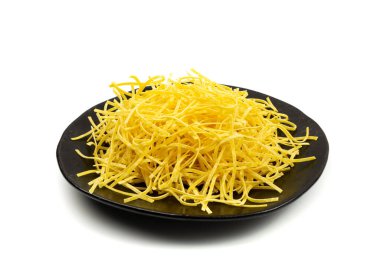 Çiğ sarı İtalyan tagliatelle makarnası. Ev yapımı kuru erişte, ince makarna kurdeleleri, izole edilmiş kısa pişmemiş spagetti yığını.