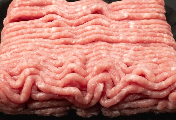Pork mince meat texture background. Ground fresh pig fillet textured pattern, uncooked pork mincemeat, raw forcemeat, farce meat closeup