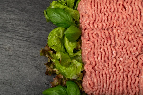 Turkey mince meat mockup. Ground fillet on black background with copy space, uncooked turkey mincemeat flat lay, raw forcemeat, fresh farce meat portion with greens top view
