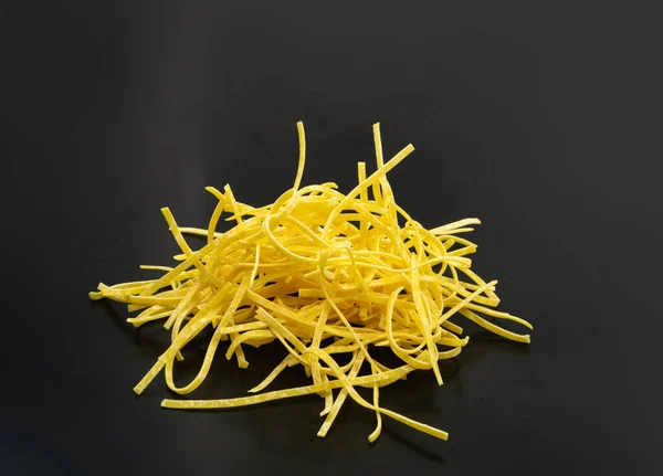 生の黄色のイタリアのタグリアテッレパスタ 卵手作りドライリボン麺 薄いマカロニリボン 短い調理されたスパゲティ孤立 — ストック写真